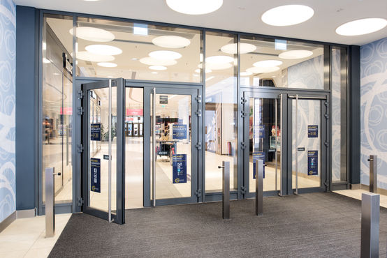Porte automatiche in vetro GEZE nel paravento della zona di entrata del centro commerciale Milaneo.