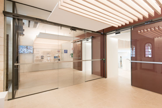Le porte scorrevoli tutto vetro e i sistemi di controllo accessi separano le aree pubbliche dagli uffici.