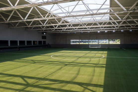 Die DFB-Fußballhalle mit Schattenspiel auf dem Spielfeld und Blick auf die Deckenkonstruktion.