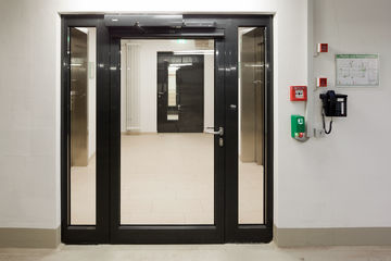Electro-hydraulic swing door drive system for 2-leaf fire and smoke protection doors with integrated closing sequence control in the Augustinum retirement complex, Stuttgart.