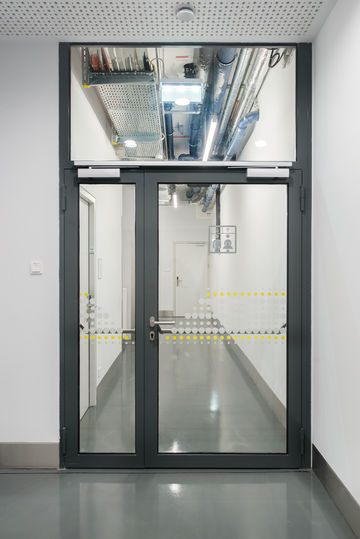 Drzwi przeciwpożarowe z funkcją swobodnego ruchu wahadłowego i komfortową funkcją zatrzaskową z techniką samozamykaczy GEZE. Zdjęcie: Sigrid Rauchdobler dla GEZE GmbH